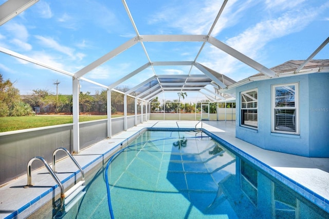 view of pool with a patio area and glass enclosure