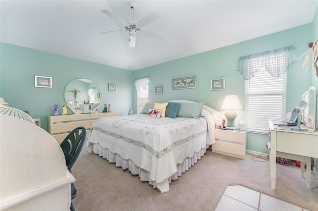 bedroom with ceiling fan, light carpet, and multiple windows