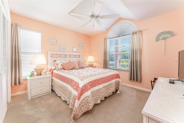 bedroom with a closet, ceiling fan, lofted ceiling, and light colored carpet