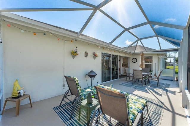 view of patio featuring glass enclosure