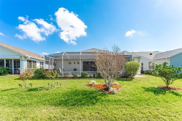 rear view of property featuring a lanai and a lawn