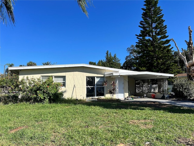 view of front of house with a front lawn and a carport