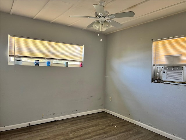 empty room featuring dark wood-type flooring, ceiling fan, a healthy amount of sunlight, and cooling unit