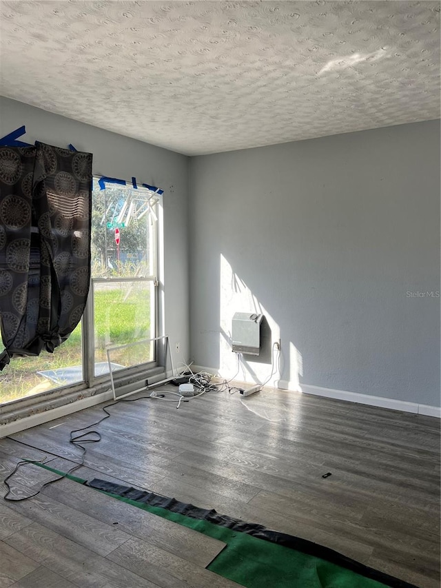 empty room featuring hardwood / wood-style flooring and a textured ceiling