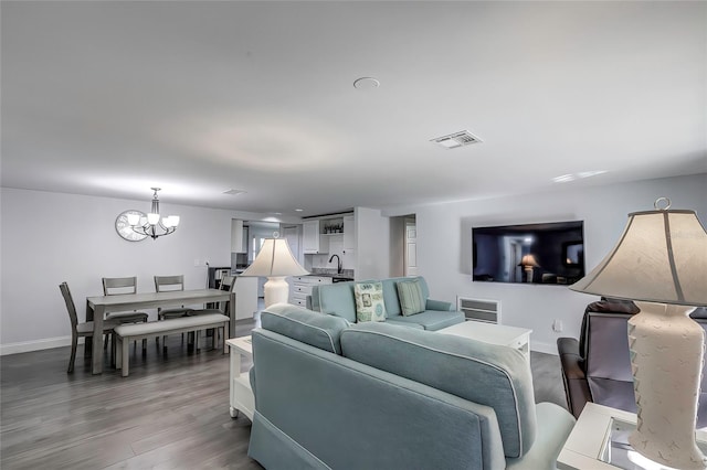 living room featuring sink, hardwood / wood-style flooring, and a notable chandelier