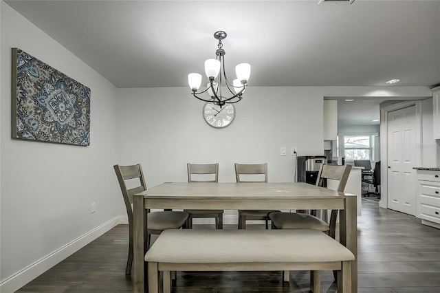 dining area featuring dark wood-type flooring and a chandelier