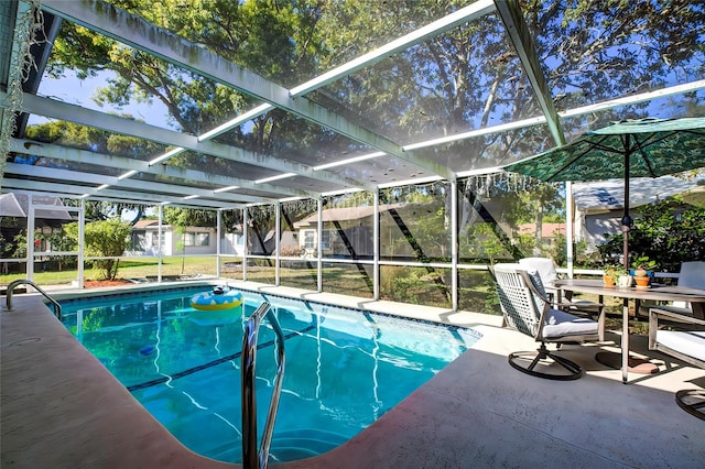 view of pool with a lawn, glass enclosure, and a patio area