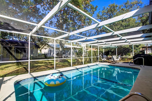 view of swimming pool with a lanai, a grill, and a patio area