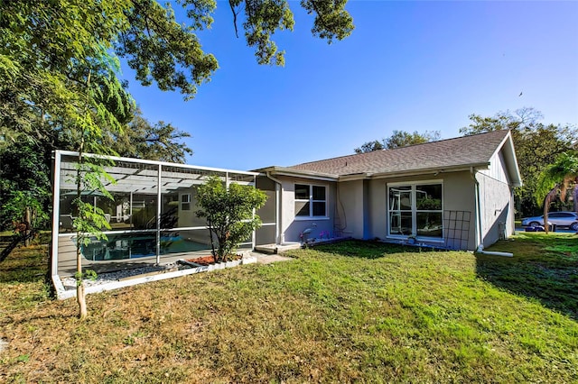 rear view of property featuring a lanai and a yard