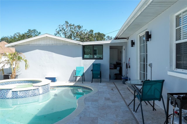 view of swimming pool featuring an in ground hot tub and a patio