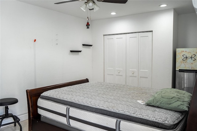 bedroom featuring a closet, ceiling fan, and stainless steel refrigerator