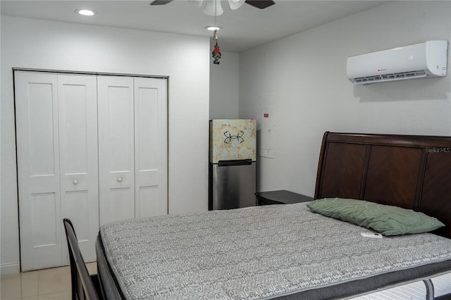 tiled bedroom with a closet, a wall unit AC, ceiling fan, and stainless steel refrigerator