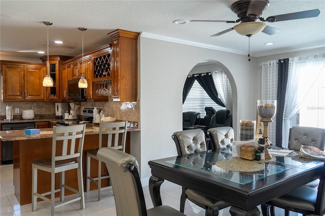 dining space featuring a textured ceiling, ornamental molding, light tile patterned flooring, and a wealth of natural light