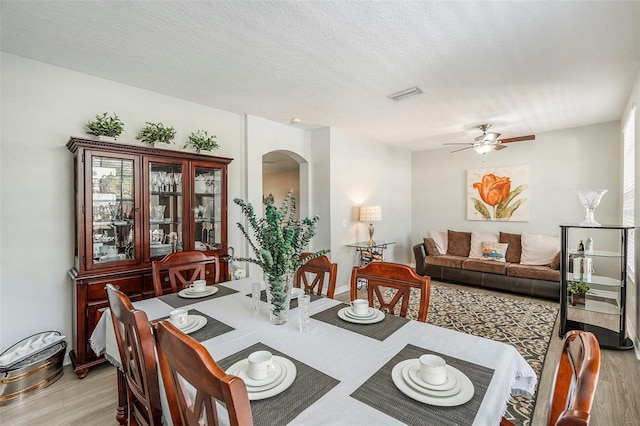 dining area featuring light hardwood / wood-style floors, a textured ceiling, and ceiling fan