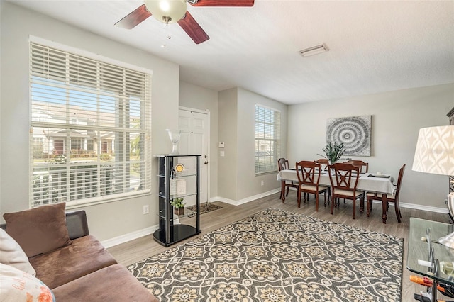 living room featuring ceiling fan, a textured ceiling, and hardwood / wood-style floors