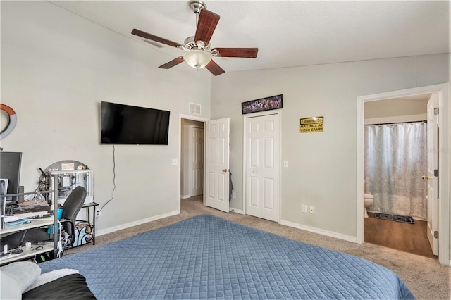 bedroom with ceiling fan, carpet flooring, vaulted ceiling, and ensuite bathroom