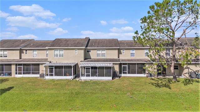 back of house featuring a yard and a sunroom