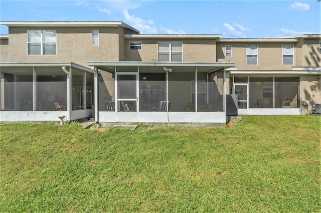 rear view of property featuring a yard and a sunroom