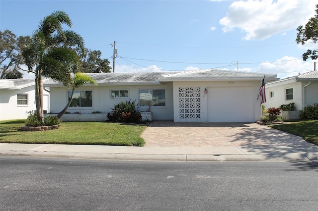 ranch-style house featuring a front yard and a garage