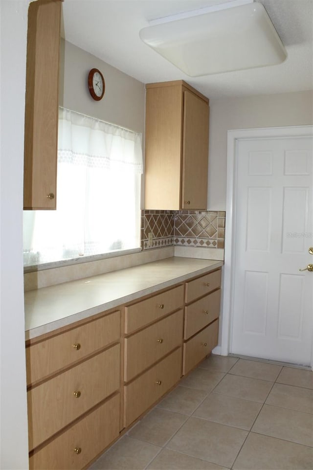 kitchen with light brown cabinetry, decorative backsplash, and light tile patterned floors