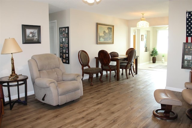 living area with an inviting chandelier and hardwood / wood-style flooring