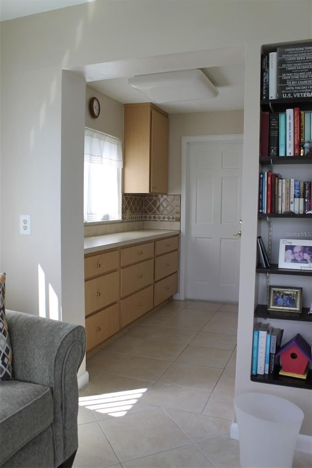 kitchen with tasteful backsplash, light tile patterned floors, and light brown cabinets