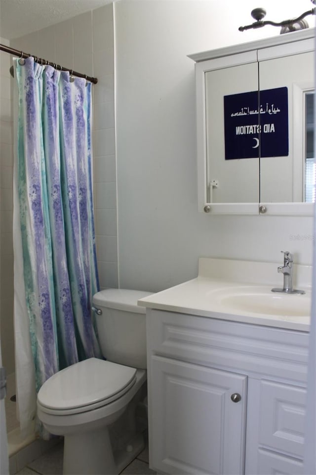 bathroom featuring toilet, curtained shower, vanity, and tile patterned floors