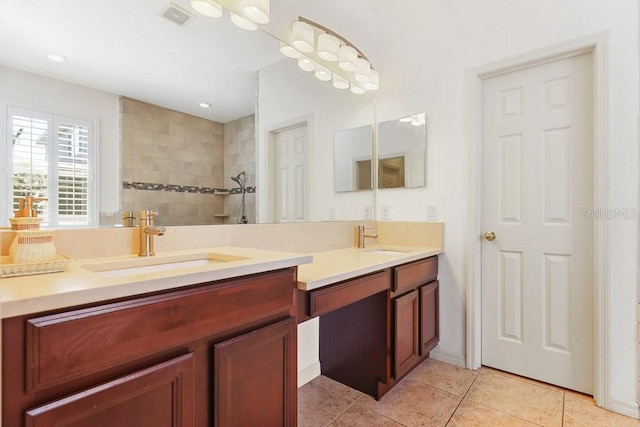 bathroom featuring vanity, tile patterned flooring, and tiled shower