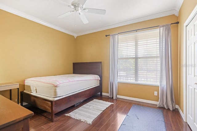 bedroom with dark wood-type flooring, crown molding, a closet, and ceiling fan