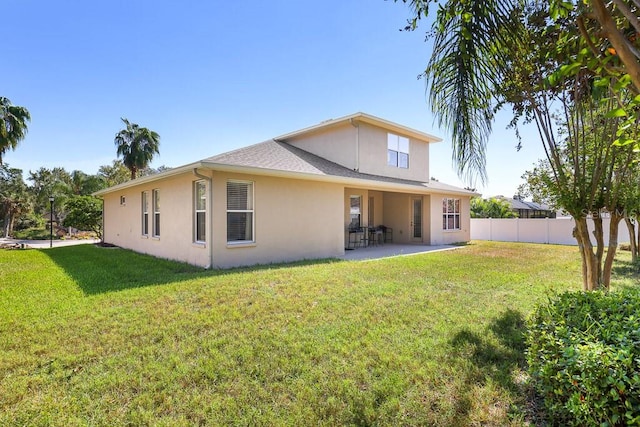 rear view of house featuring a patio and a yard