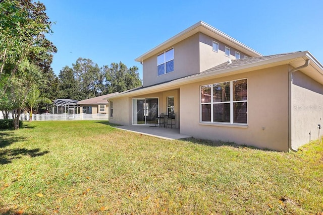 rear view of house featuring a patio and a lawn