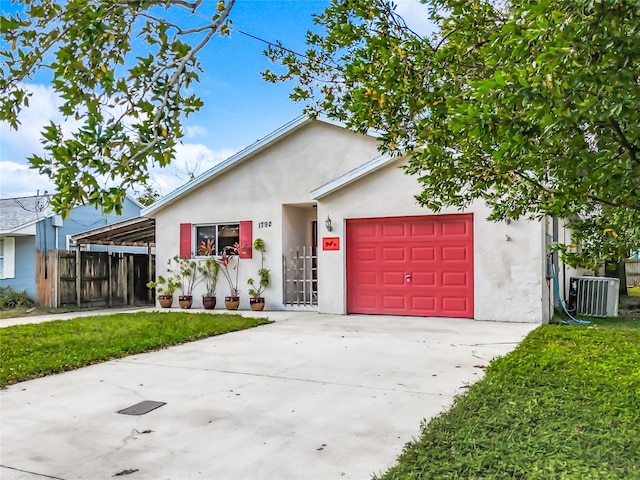 ranch-style house featuring a front yard, central AC unit, and a garage