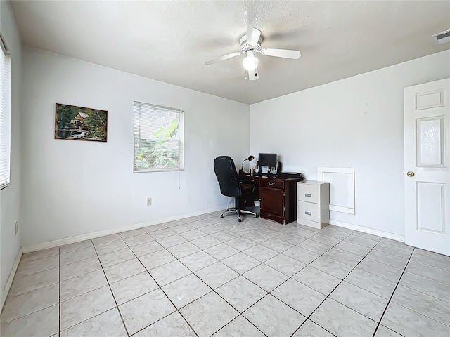 office area with a textured ceiling, light tile patterned floors, and ceiling fan