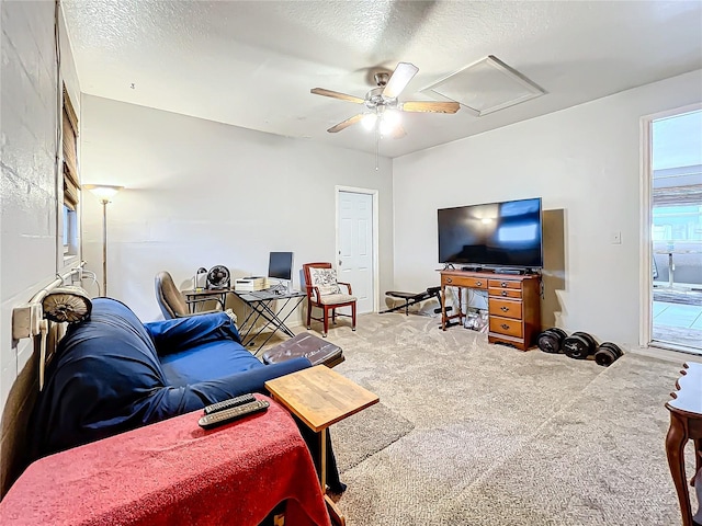 carpeted living room featuring a textured ceiling and ceiling fan