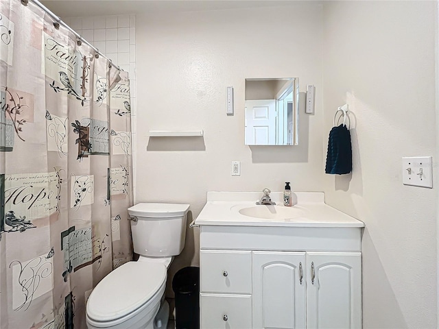 bathroom featuring vanity, toilet, and curtained shower