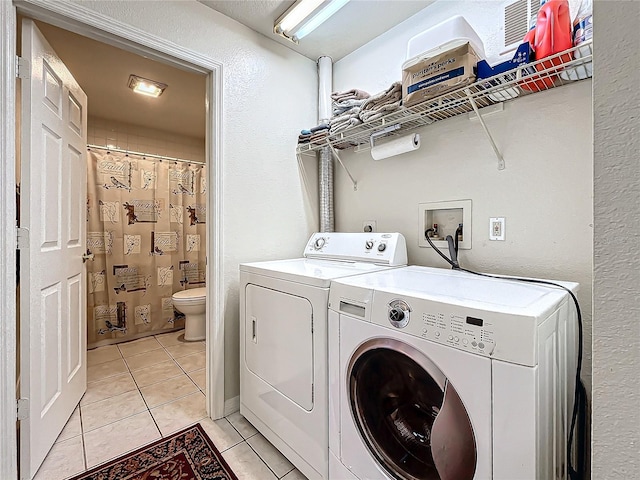 laundry room with light tile patterned floors and separate washer and dryer