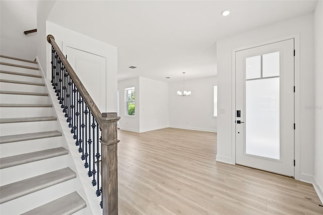 entrance foyer with light wood-style floors, stairway, baseboards, an inviting chandelier, and recessed lighting