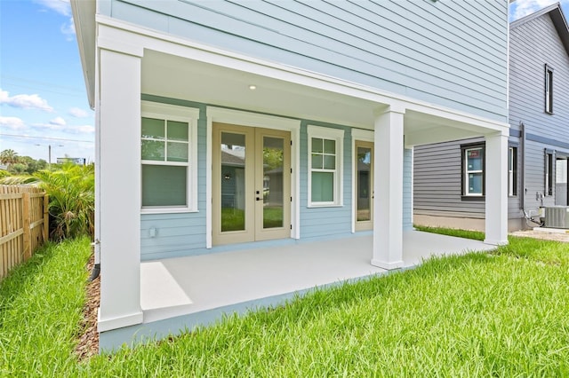 property entrance featuring french doors, cooling unit, and a yard