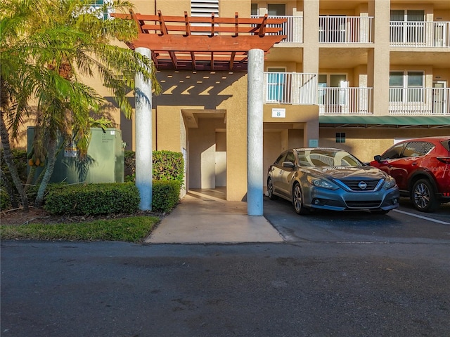 view of exterior entry with a carport and a balcony