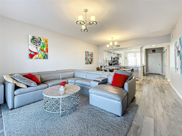 living room featuring an inviting chandelier and light wood-type flooring