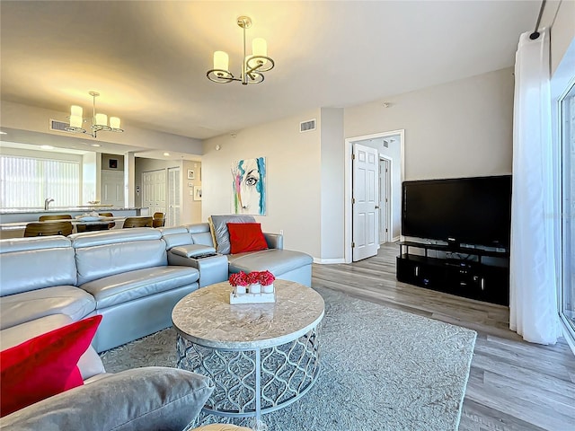 living room featuring light hardwood / wood-style floors and a chandelier