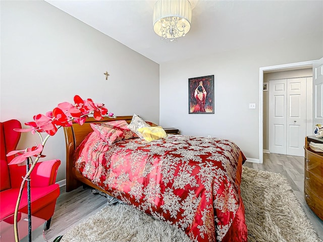 bedroom with a notable chandelier and hardwood / wood-style flooring