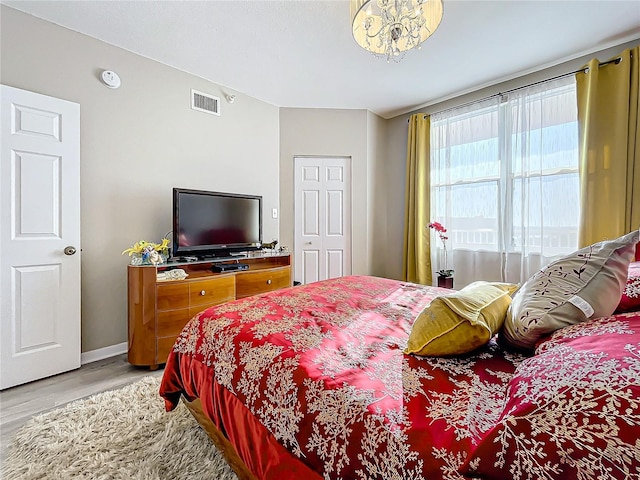 bedroom featuring hardwood / wood-style floors and an inviting chandelier