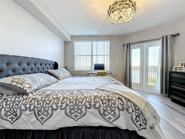 bedroom featuring light hardwood / wood-style flooring, multiple windows, and access to exterior