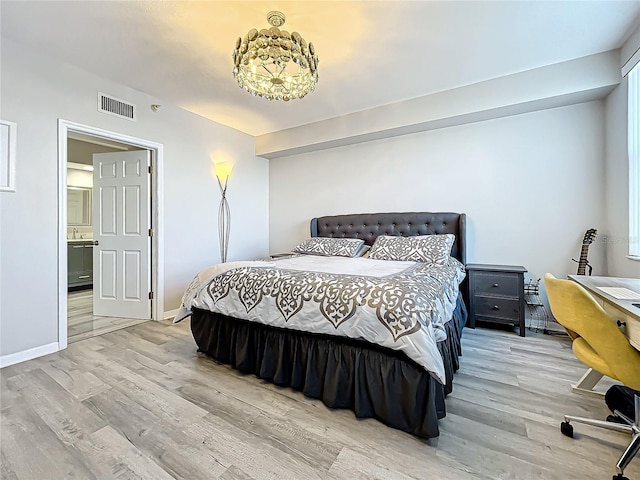 bedroom with connected bathroom and light hardwood / wood-style flooring