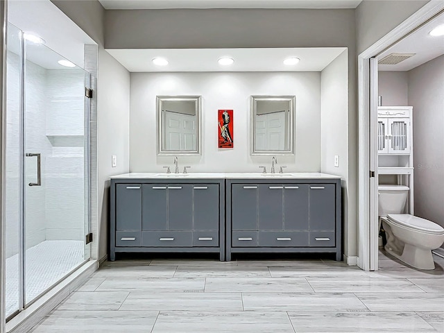 bathroom featuring vanity, toilet, and an enclosed shower