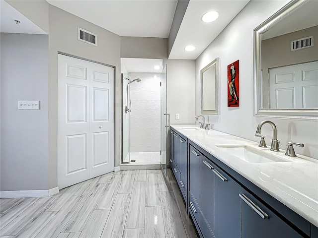 bathroom with vanity, wood-type flooring, and a shower with door