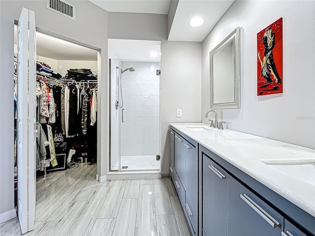 bathroom with a shower with door and vanity