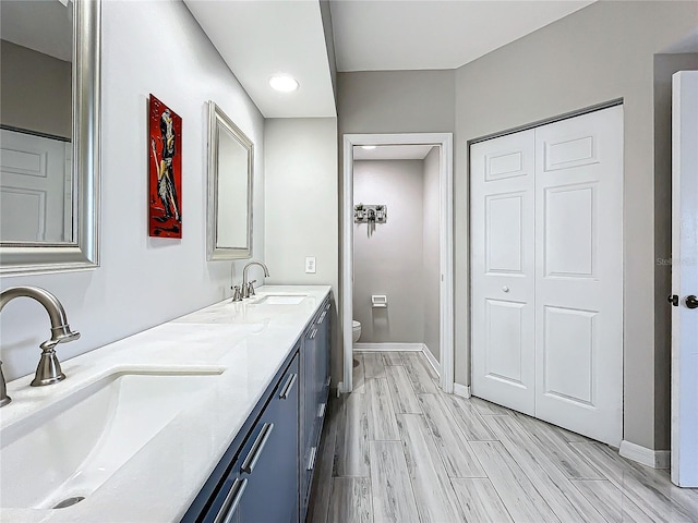 bathroom featuring vanity, toilet, and hardwood / wood-style floors