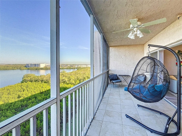 sunroom / solarium featuring a water view and ceiling fan